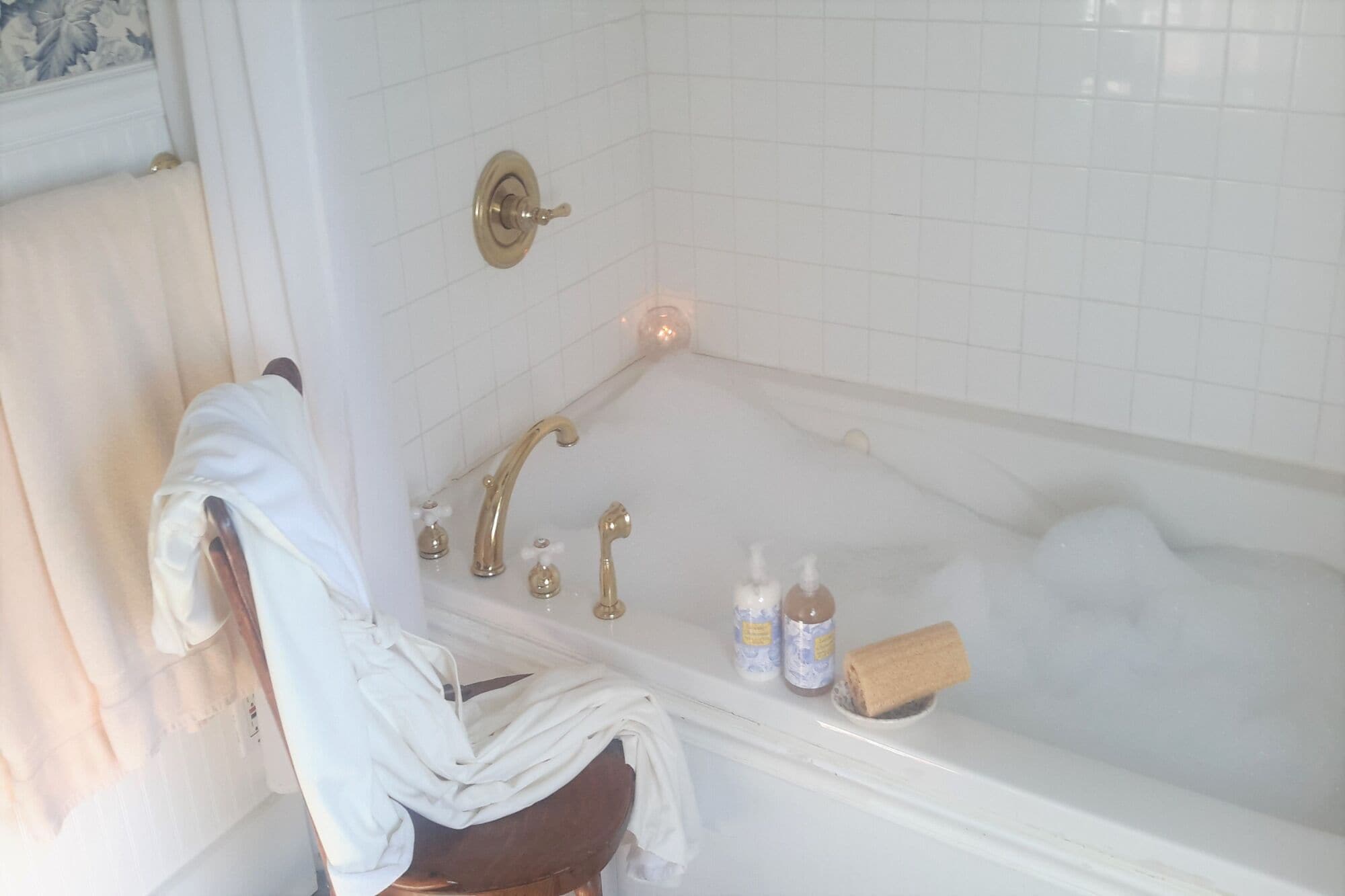 A bathroom with a bathtub, a towel rack, and toiletries.