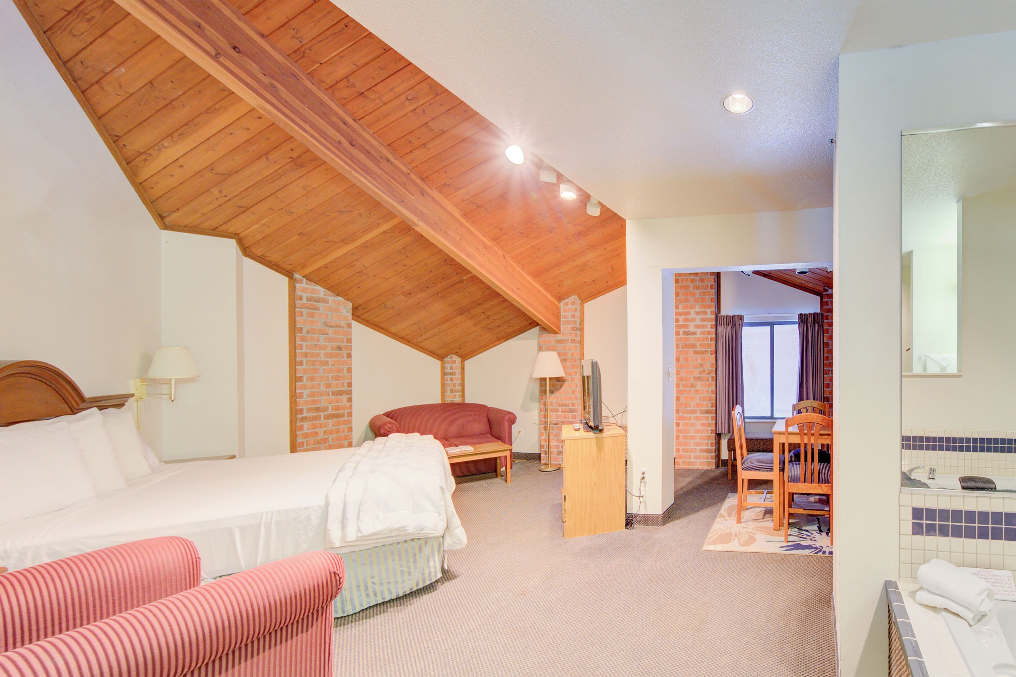 Ein Schlafzimmer mit Bett, Sofa, Schreibtisch und Badezimmer.