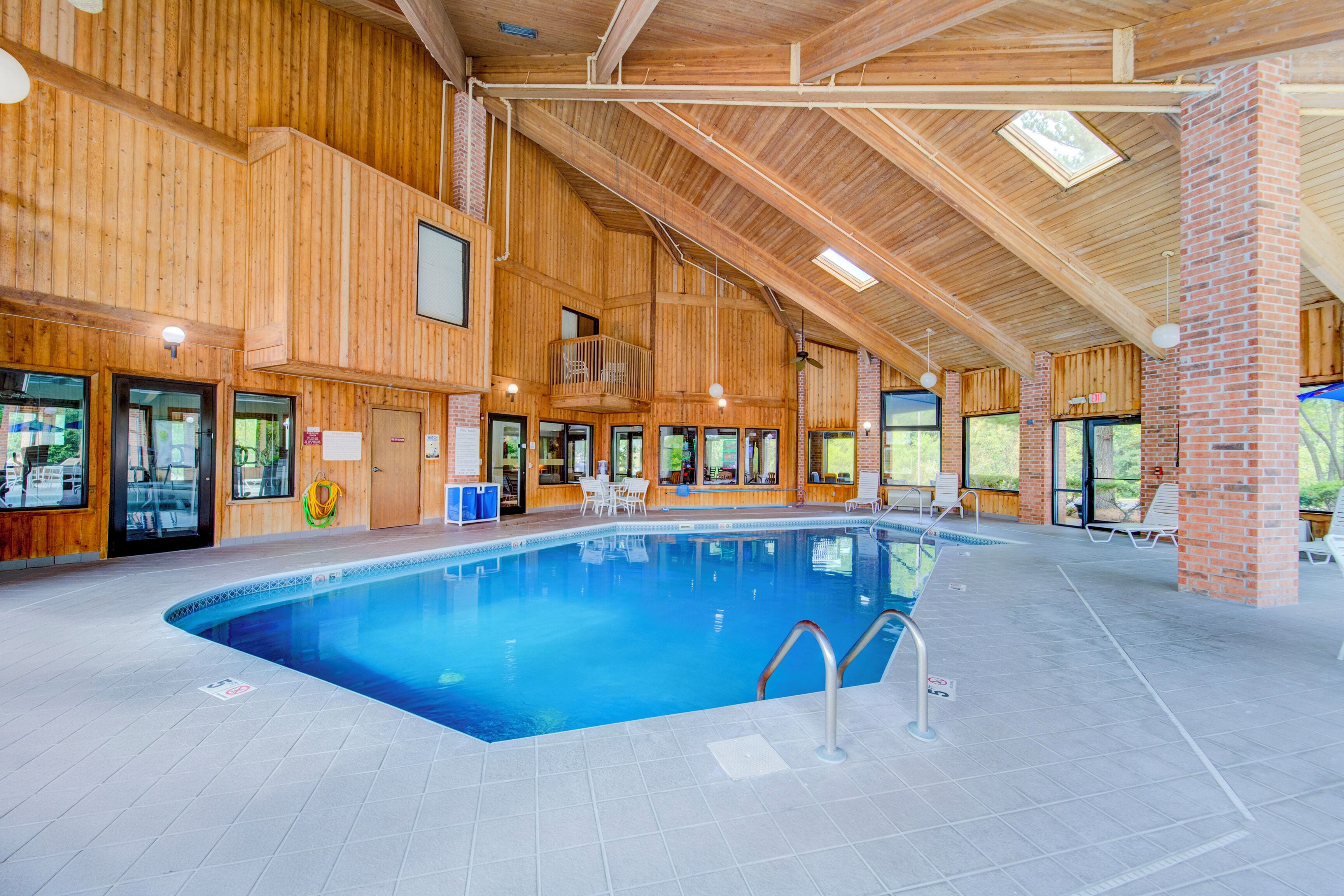 An indoor swimming pool with wooden walls and a high ceiling.