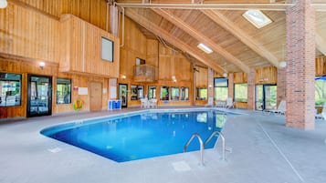 An indoor swimming pool with wooden walls and a high ceiling.
