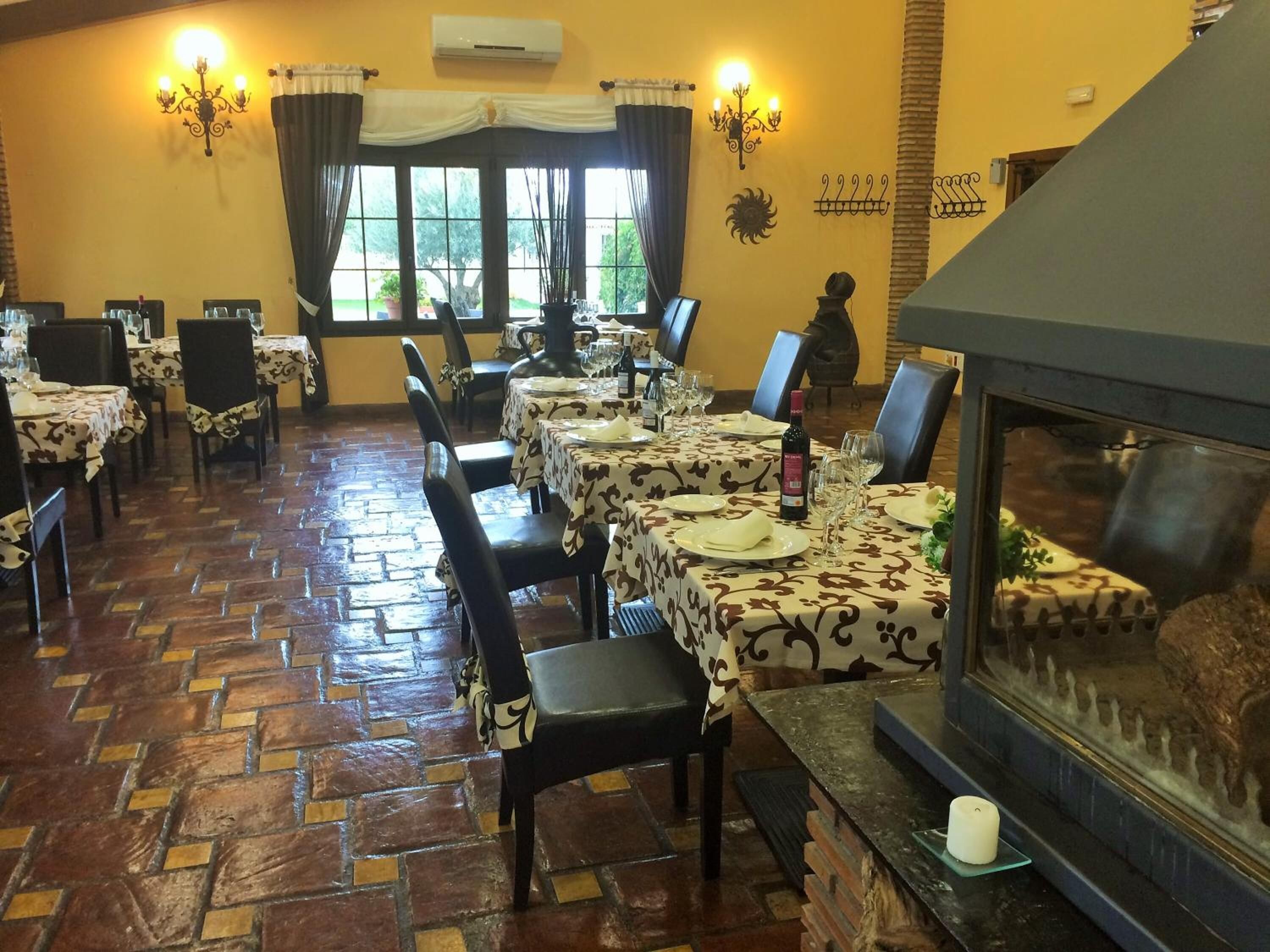 Un restaurante con varias mesas, sillas y una chimenea.