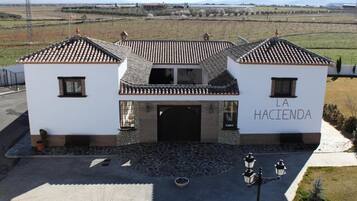 A two-story building with a tiled roof and a stone facade. The name "LA HACIENDA" is visible on the front wall.