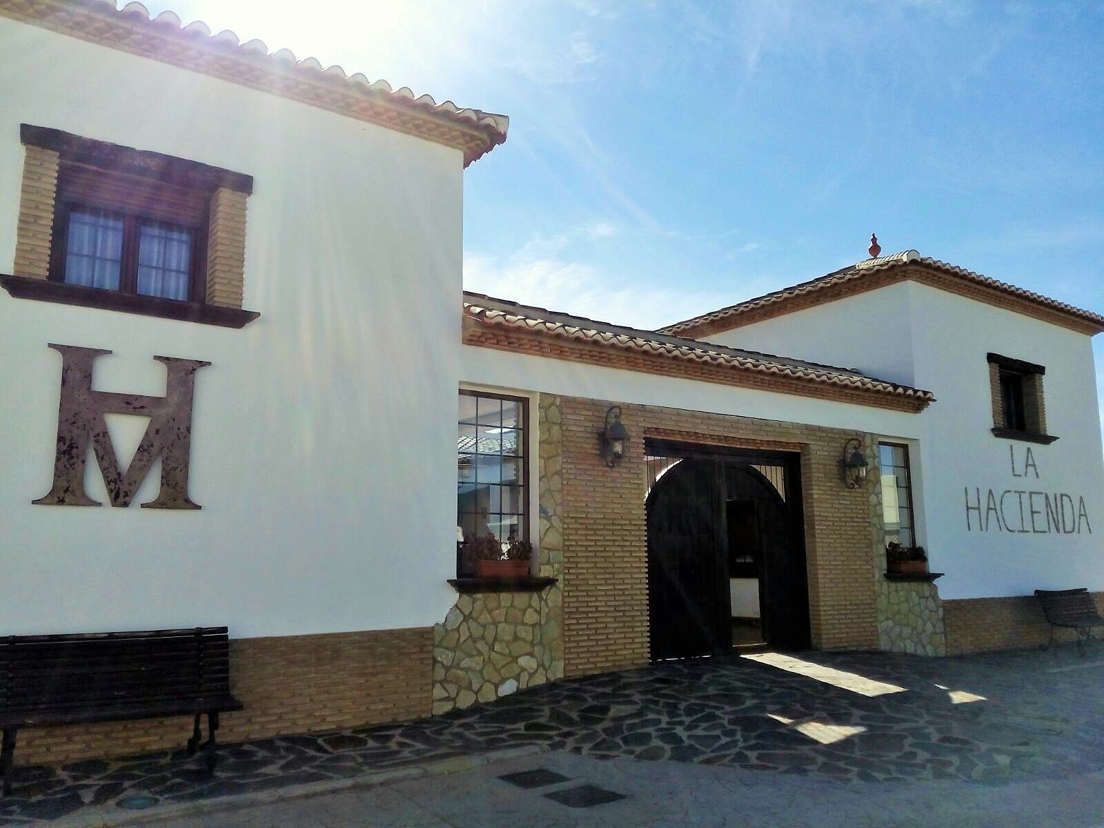Un edificio con una 'H' grande a la izquierda y 'LA HACIENDA' a la derecha.
