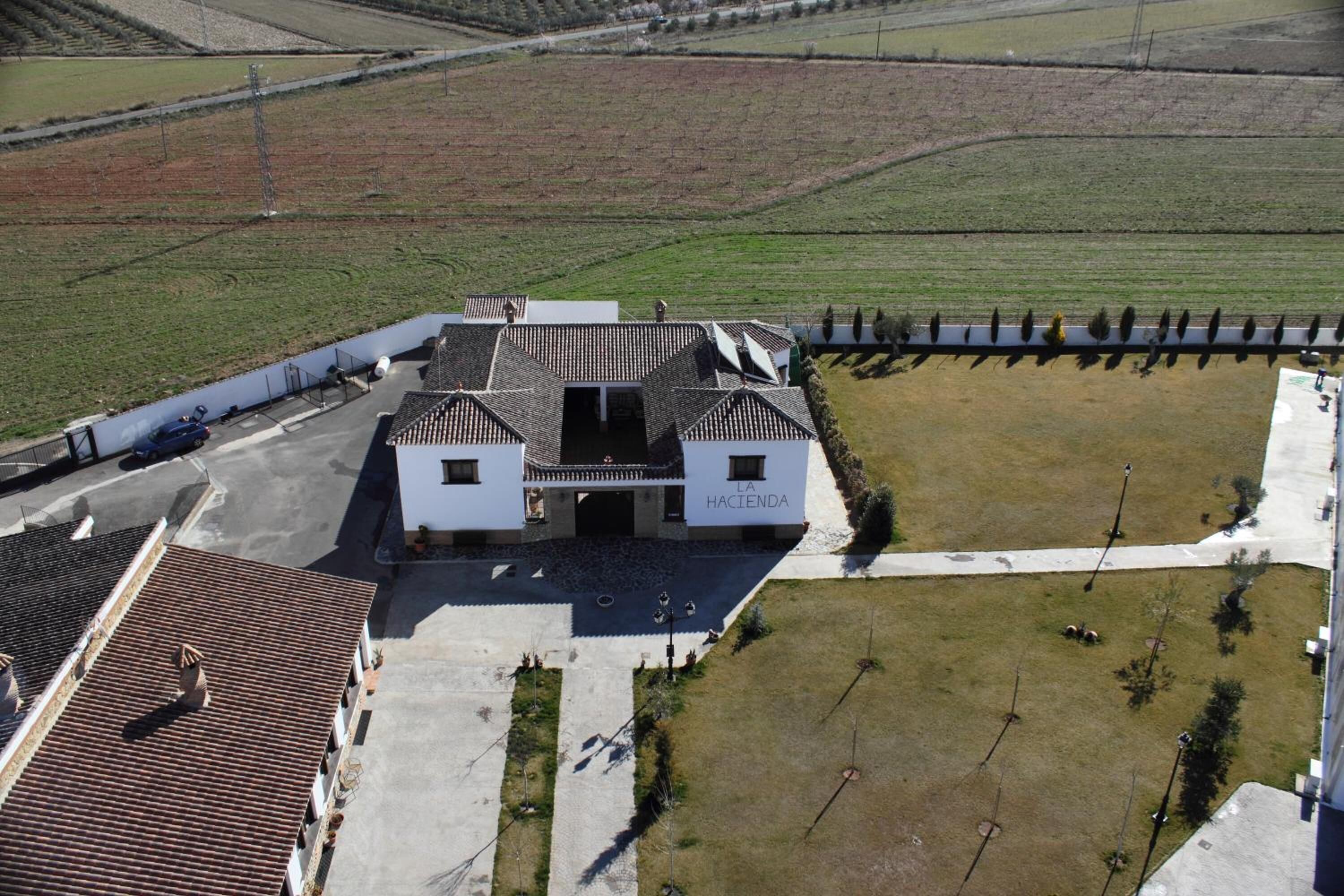 Un bâtiment avec un toit recouvert de tuiles et une enseigne sur laquelle on peut lire « LA HACIENDA ».