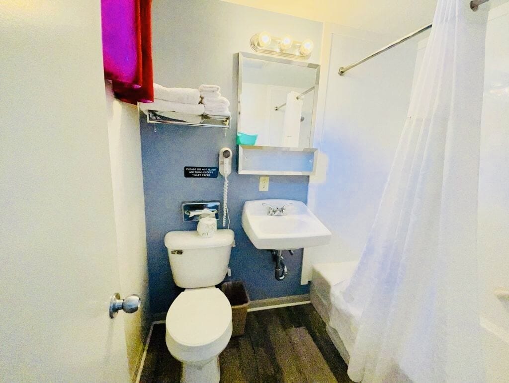 Ein kleines Badezimmer mit Toilette, Waschbecken und Spiegel darüber.