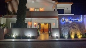 A modern two-story building with a well-lit entrance and a sign that reads "Casualismo." - Casa Rosario (Valladolid)