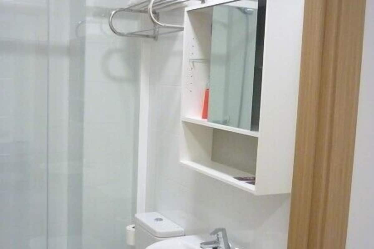 A bathroom with a toilet, sink, and glass shower enclosure.