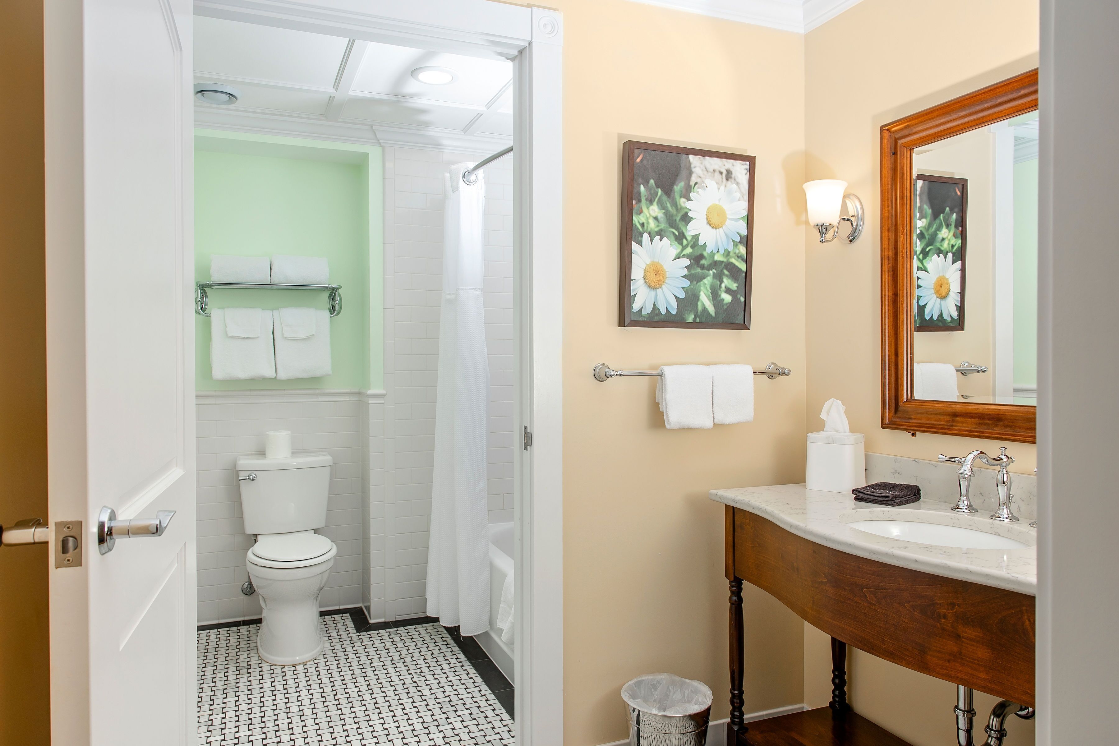 Een badkamer met toilet, douche, wastafel en spiegel.