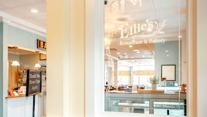 A restaurant with a sign reading "Ellie's Restaurant & Bakery" and a sign saying "Thank You. Please Come Again."