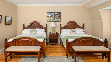 A double room with two wooden beds, a nightstand, a bench, and a painting on the wall.