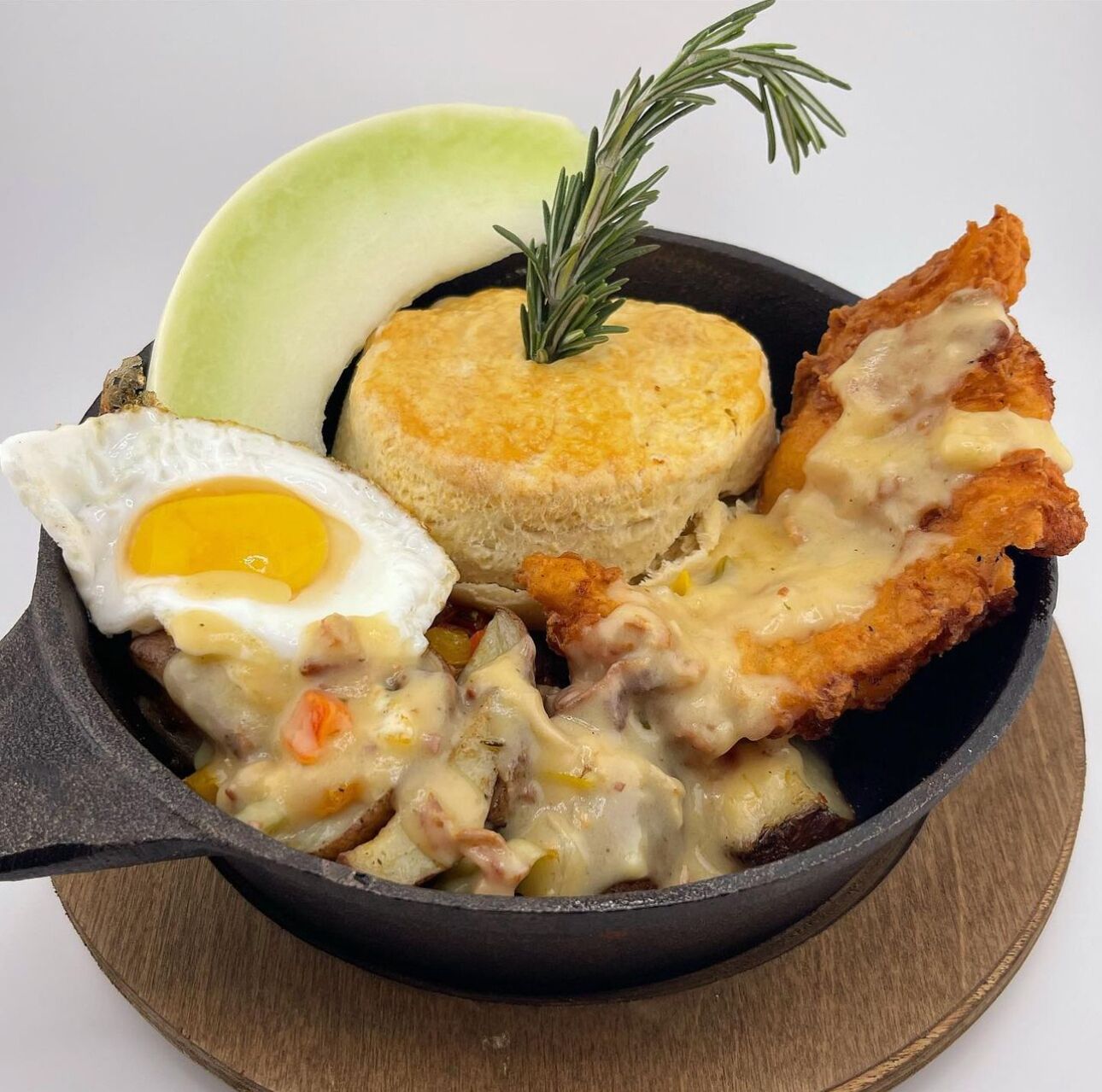 Prato com ovos fritos, biscoitos e abacate como acompanhamento.