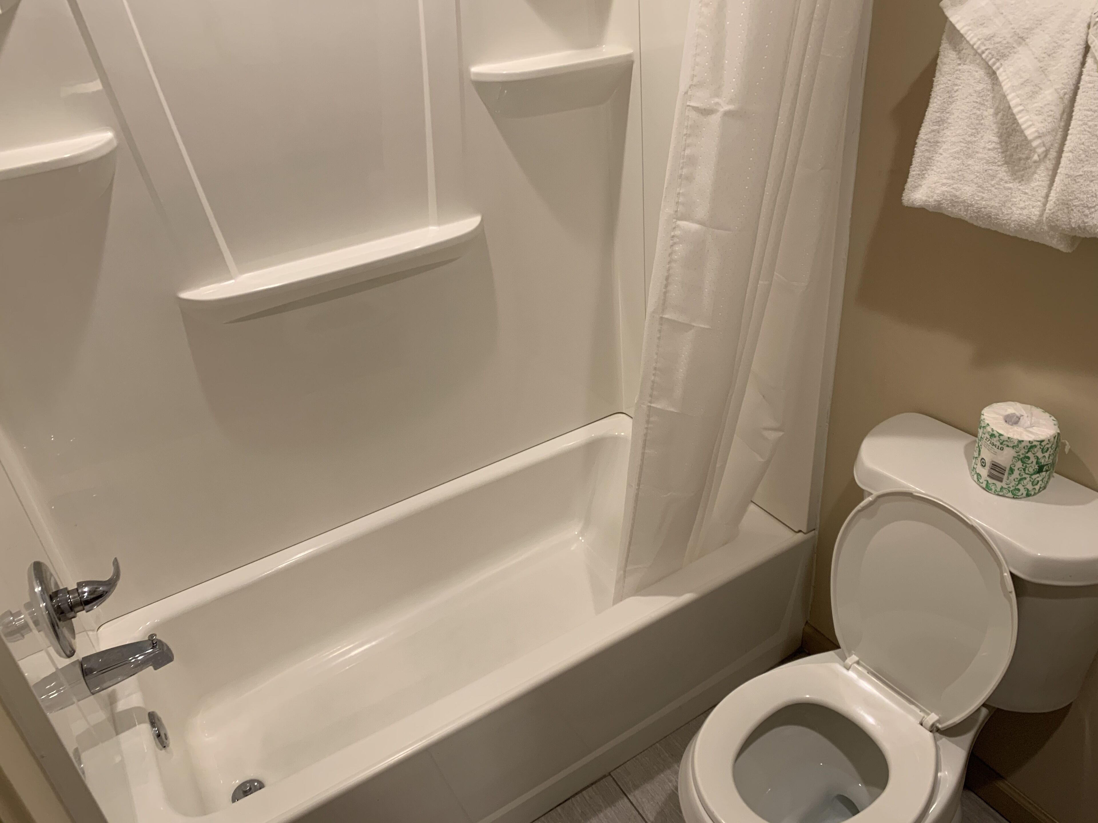 Un baño con bañera, inodoro y cortina de ducha.