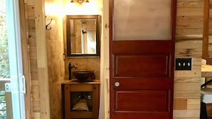 A wooden interior with a sliding door leading to a bathroom. - Barefoot Hills (Dahlonega)