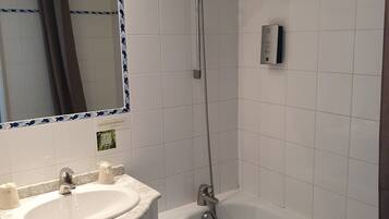 A bathroom with a white sink, a mirror, and a bathtub.