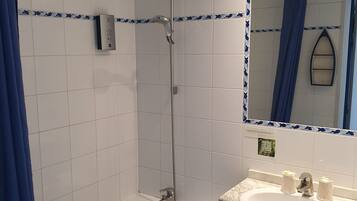 Une salle de bain avec une baignoire, un lavabo et une douche.