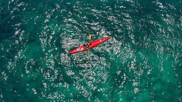 A red kayak on a turquoise sea.