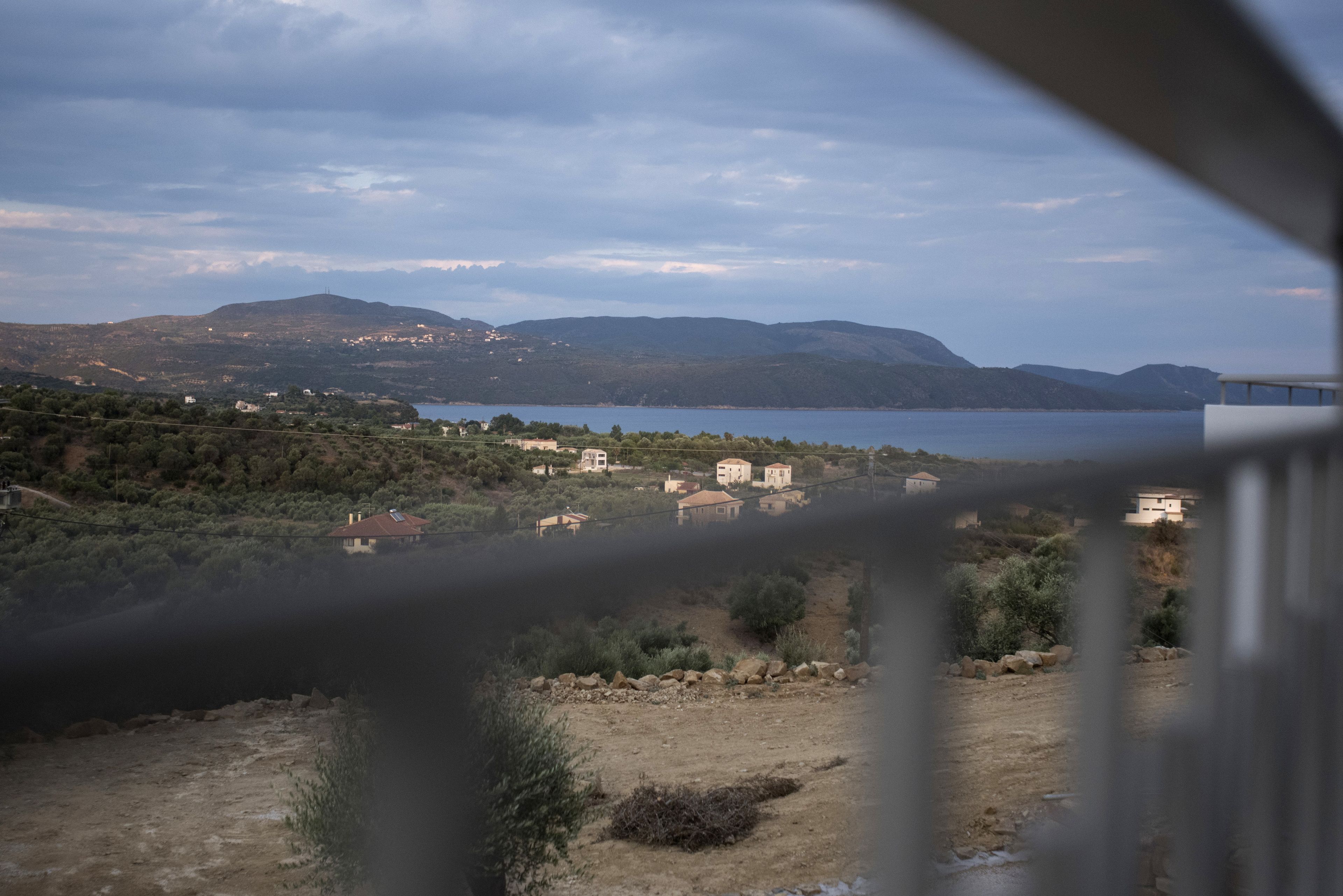 Un paysage côtier avec des maisons et une étendue d’eau.