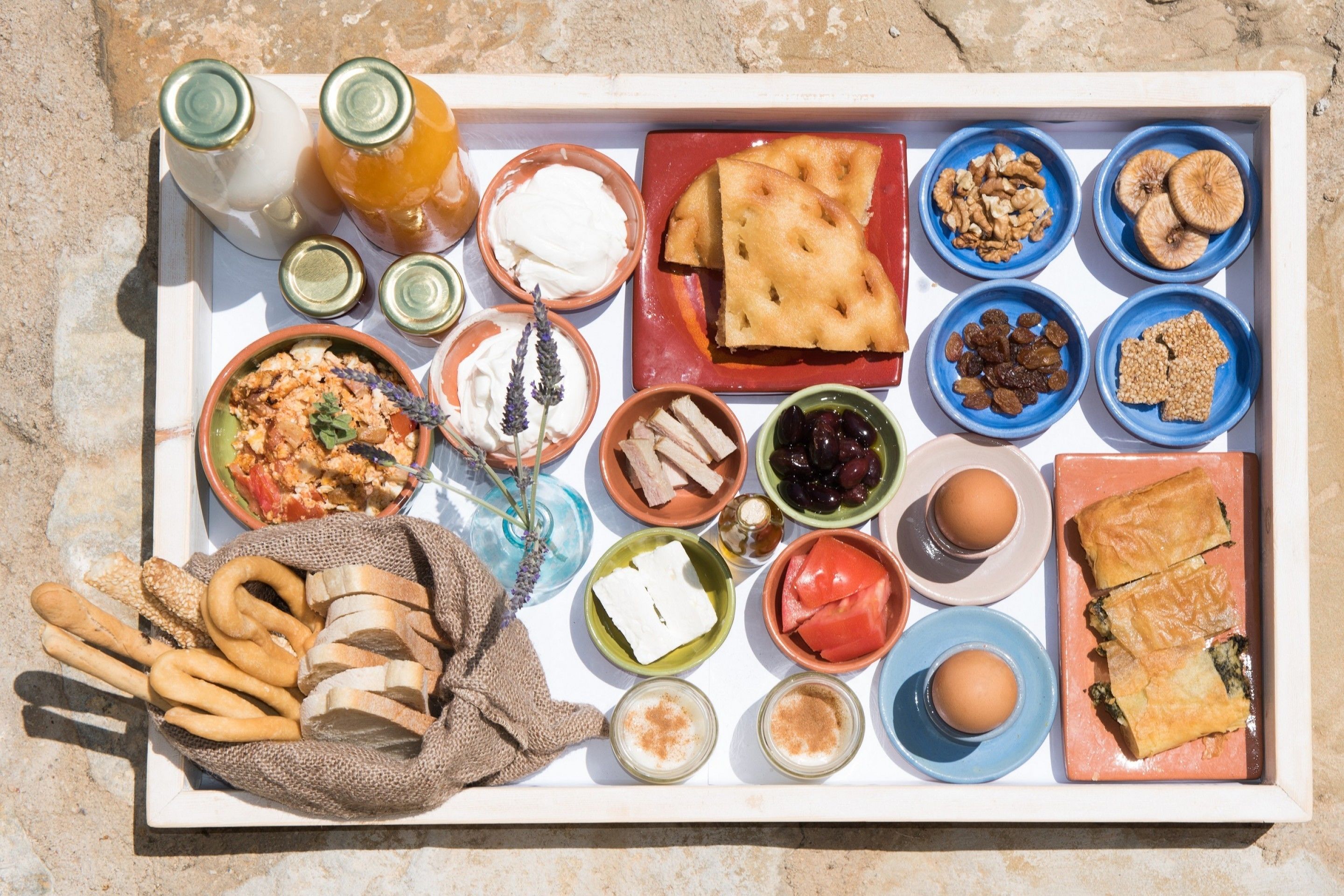 Una bandeja con diferentes alimentos, incluyendo pan, nueces y frutas.