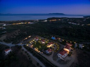 Vista aérea de una zona residencial costera con casas, carreteras y una masa de agua al fondo.