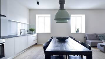 A modern kitchen with a dining area, a sofa, and a coffee table.