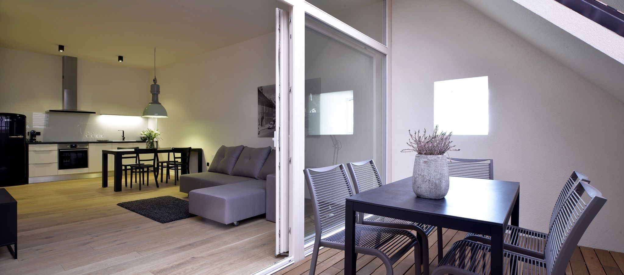 Un apartamento moderno con comedor, sofá y cocina al fondo.