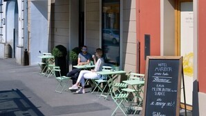 A hotel exterior with outdoor seating and a signboard. - Hotel Maribor, City apartments (Maribor)