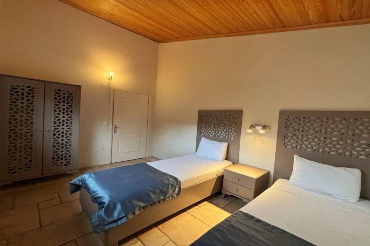 Een slaapkamer met twee bedden, een kledingkast en een deur.
