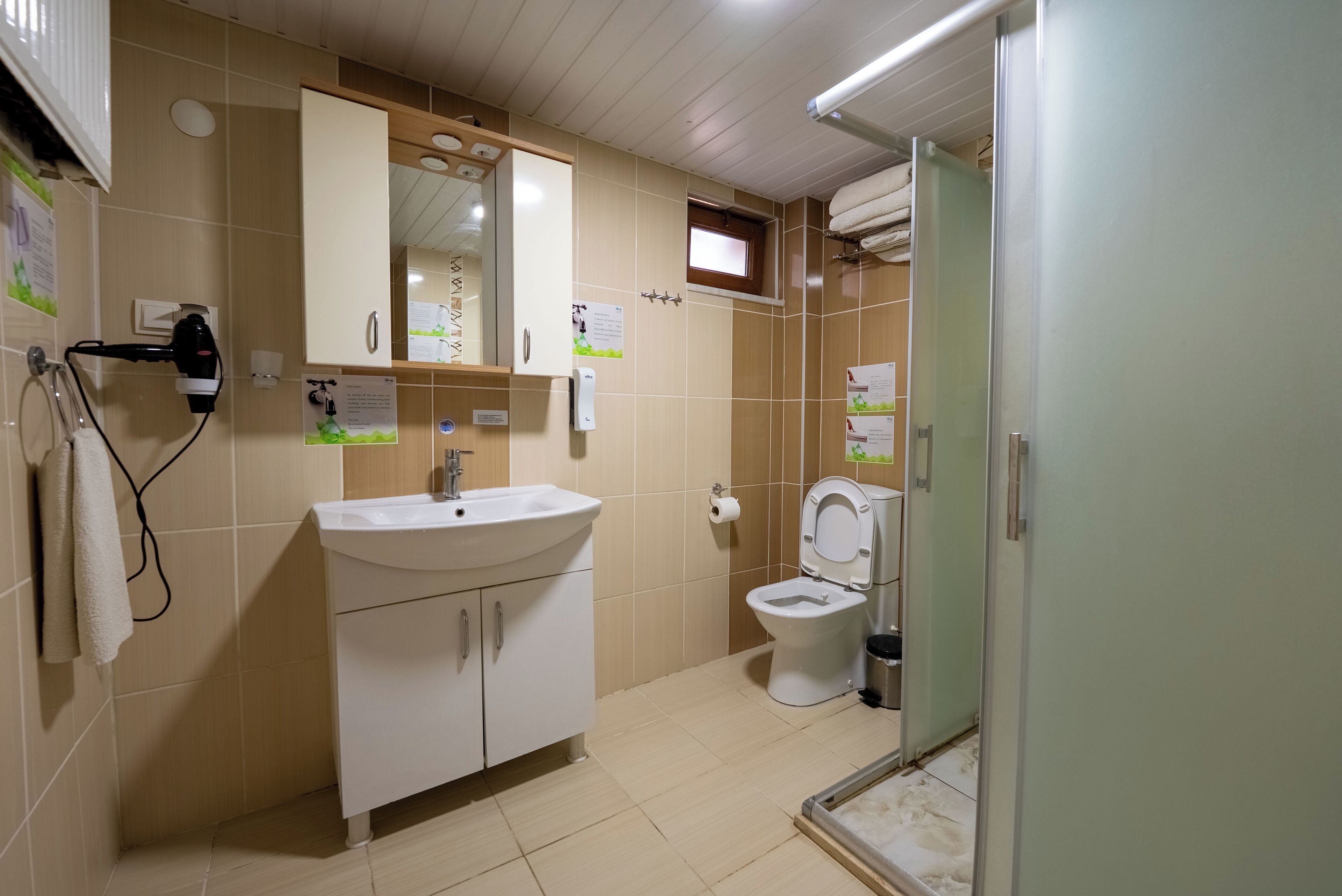 A bathroom with a sink, mirror, toilet, and towel rack.