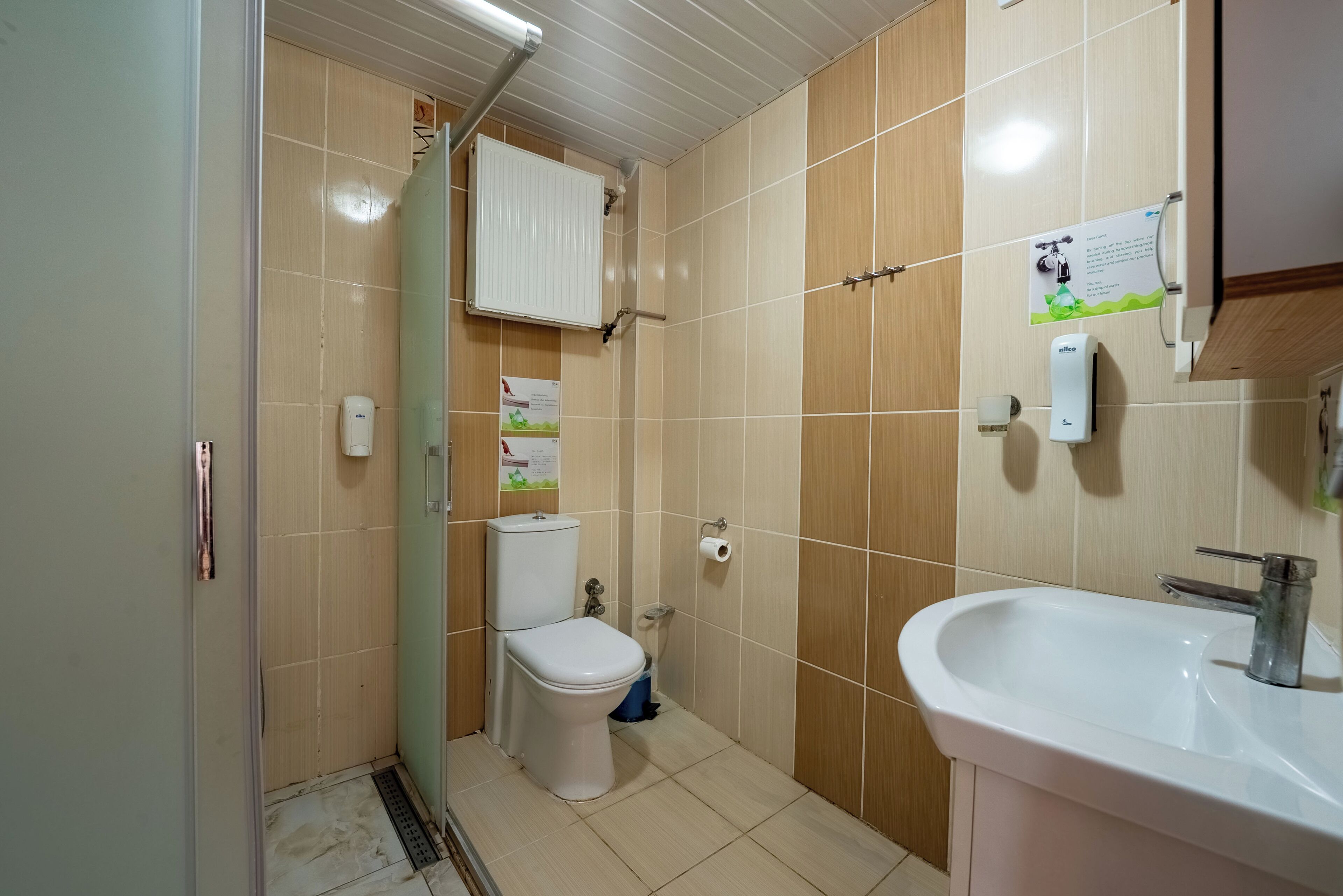 Une salle de bain avec des toilettes, un lavabo et une douche.