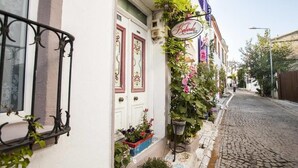 Un immeuble à la façade blanche, doté d ’un balcon orné de plantes en pot et d’une enseigne indiquant le nom « Kalinda ».