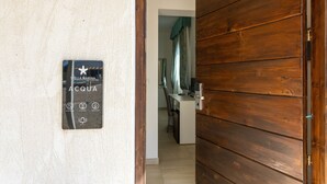Una puerta de madera que da a una habitación con un cartel que indica "Stella Marina Acqua" e iconos que representan servicios como piscina, restaurante y spa.