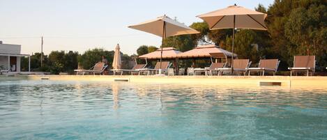 Een seizoensgebonden buitenzwembad en parasols bij het zwembad
