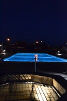Una piscina al aire libre de temporada, sombrillas, tumbonas