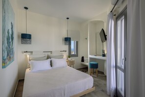 A bedroom with a bed, bedside tables, a desk, a chair, a mirror, and a window.