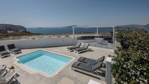 A rooftop pool area with lounge chairs and a view of the sea. - Hemera Holiday Home (Santorini)