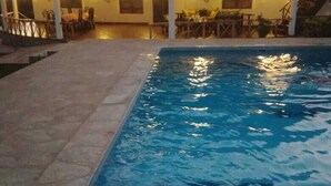 Une piscine avec une structure de toit en chaume en arrière-plan.