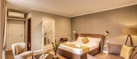 Una habitación de hotel moderna con una cama grande, un sofá, una silla y una pequeña mesa.