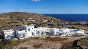 Un village côtier aux bâtiments blancs, offrant une vue dégagée sur la mer et un paysage vallonné.