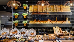 A bakery display with various breads and pastries, potted plants, and hanging light fixtures. - Gran Palas Hotel - Spa incluido (Vila-Seca)