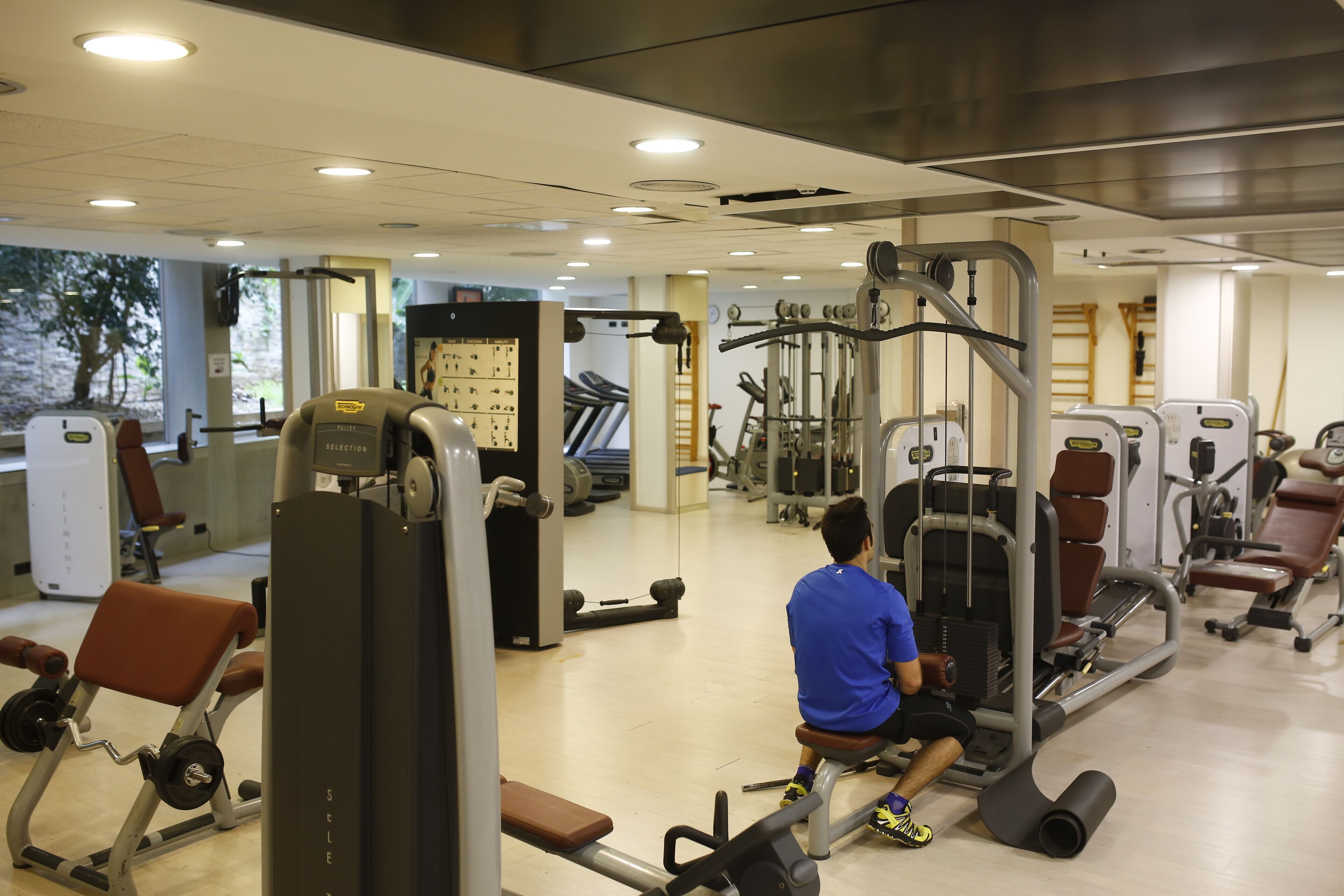 Ein Fitnessstudio mit verschiedenen Trainingsgeräten, darunter Kraftgeräte und Cardiogeräte.