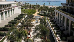 A hotel with a rooftop garden, palm trees, and a view of the beach and sea. - Gran Palas Hotel - Spa incluido (Vila-Seca)