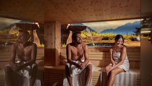 A wooden sauna with benches and a large window. - Hotel Zontaja (Galtur)