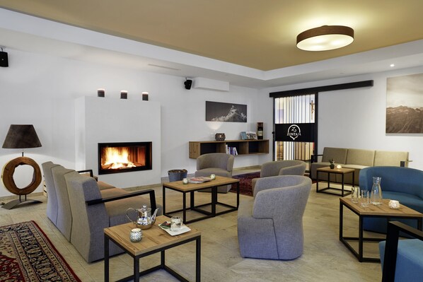 Una sala de estar moderna con chimenea, asientos cómodos y una mesa de centro.