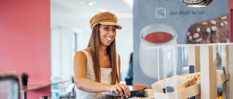 A person serving food in a modern restaurant with a red and white color scheme.