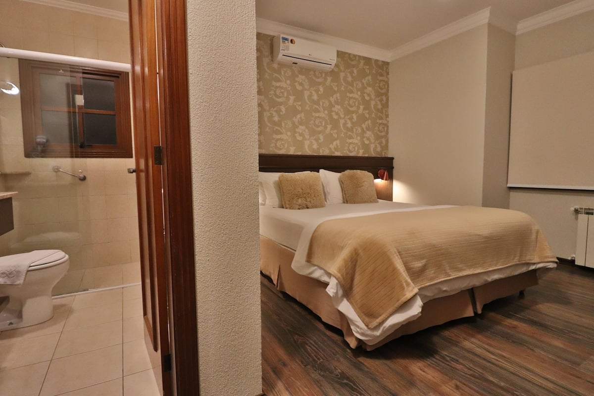 Une chambre d’hôtel avec un lit, une salle de bain et une fenêtre.