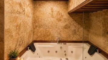 A bathroom with a freestanding bathtub, wooden paneling, and a tiled wall.