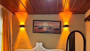 A hotel room with a bed, a painting on the wall, and two wall-mounted lights. - Onuncu Koy Hotel - Adults Only (Bursa)