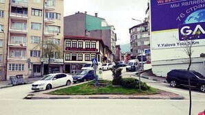 A street view with a hotel named 'GRUNCU' and a large billboard advertising 'Y. Yalova Yolu 5 Km'. - Onuncu Koy Hotel - Adults Only (Bursa)