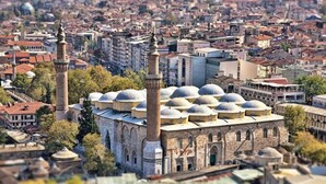 A large mosque with multiple domes and minarets, surrounded by a densely packed urban area. - Onuncu Koy Hotel - Adults Only (Bursa)