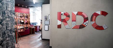 A modern interior with a wall-mounted artwork spelling "RDC" and a patterned wall to the left.